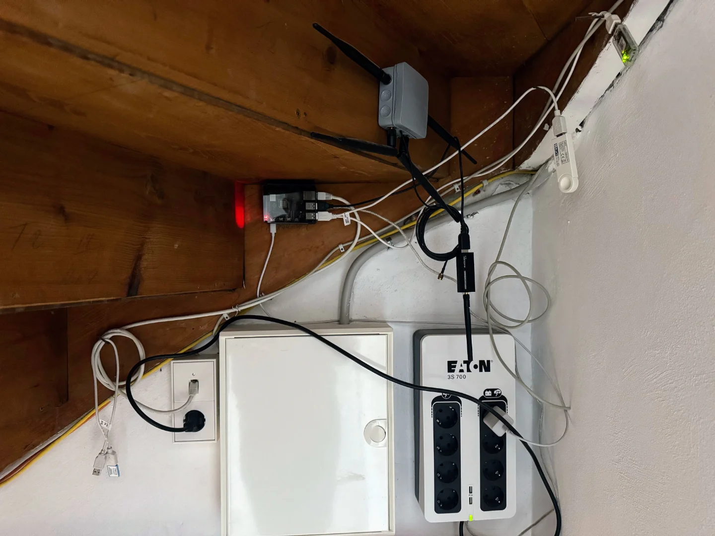 My Raspberry Pi 4 setup with a case and SD card, hanging on a wall below the stairs.