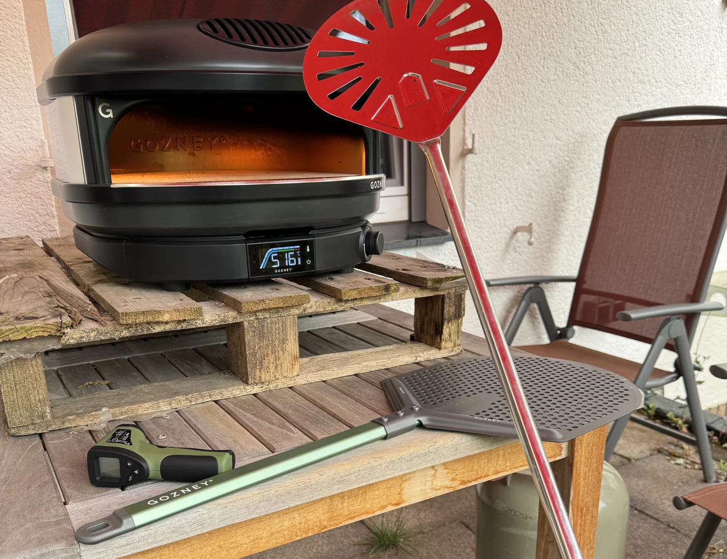 Image of the assembled oven with pizza peel, pizza turner and infrared thermometer